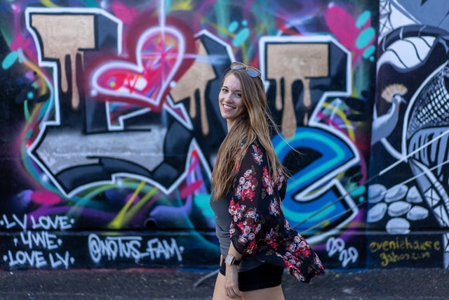Eine junge Frau läuft an einer Graffiti Wand vorbei, auf der I Love You steht